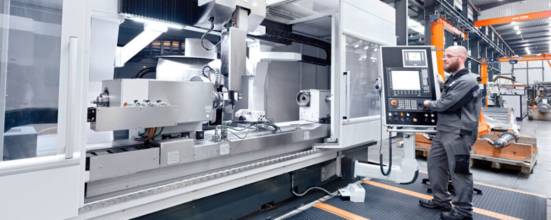 An industrial machine tool in action, powered by hydraulics.